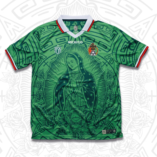 A green soccer jersey with a graphic of Lady of Guadalupe and the Azteca ball on the back. The jersey has a red and white collar and a sunstone design.
